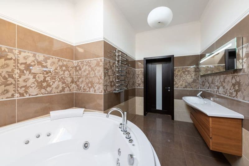A bathroom with a bathtub and tiled walls