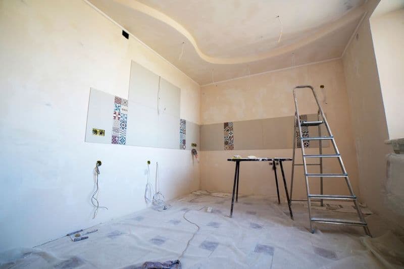 A room under renovation with paint, tiles and tools