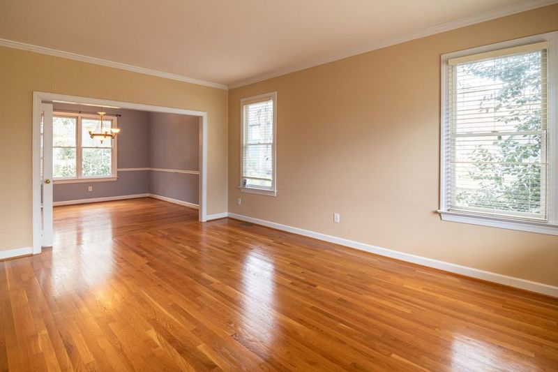 A large empty room with wooden floors and tall windows